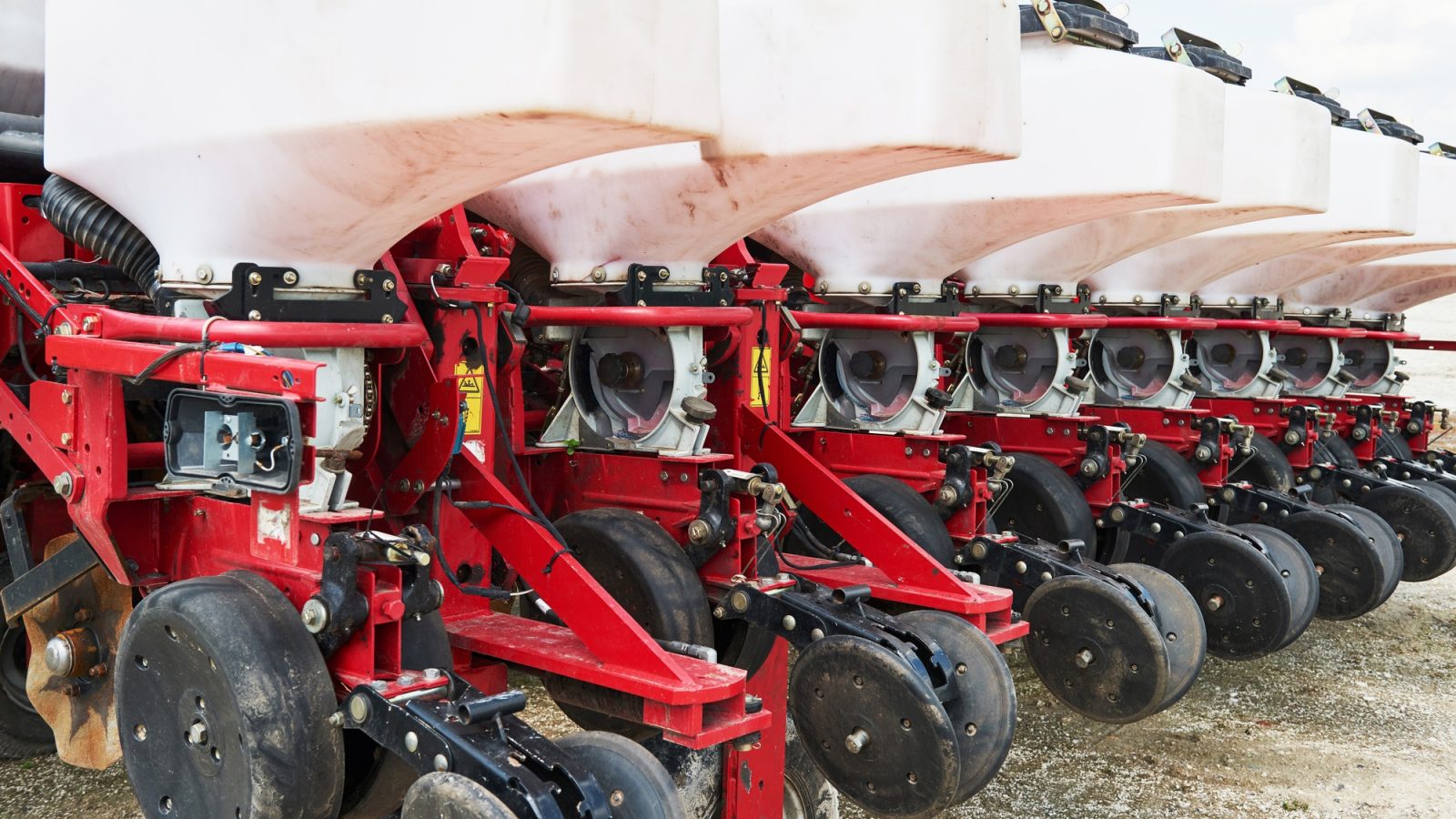 Close up of seeder attached to tractor in field. Agricultural machinery for spring works sowing